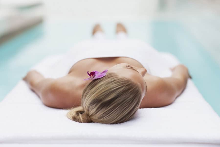 A woman lies on a treatment table in the wellness hotel. We offer great wellness hotels at our hotel booking service.